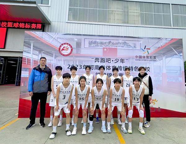 4郑州市第十九高级中学女篮教练刘文臣和女篮球队员们合影，前排右一为女篮队员黄豆同学。